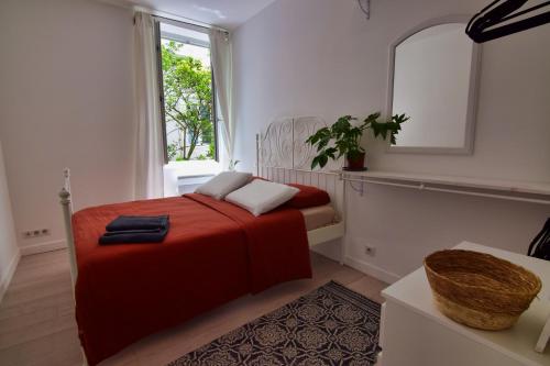 une chambre avec un lit rouge et un miroir dans l'établissement Atlantico - Arrosa, à Biarritz