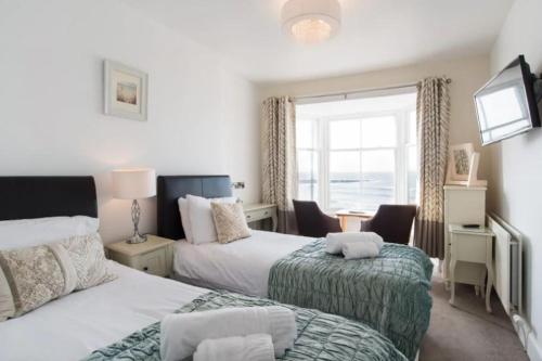 1 dormitorio con 2 camas y ventana en No 47 Marine Terrace, en Aberystwyth