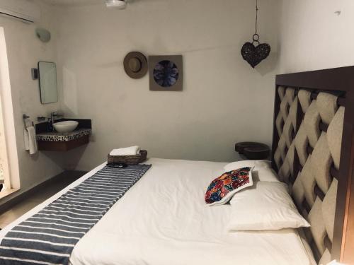 a bedroom with a large white bed with a sink at Casa Bizu in Bacalar