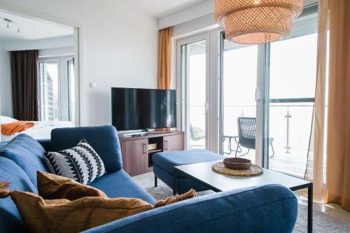 a living room with a blue couch and a tv at Apartman Balaton in Keszthely