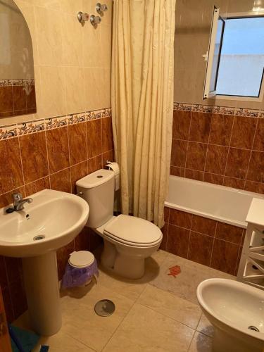 a bathroom with a toilet and a sink and a tub at Amazing 2-bedrooms apartment with pool Torrevieja center in Torrevieja