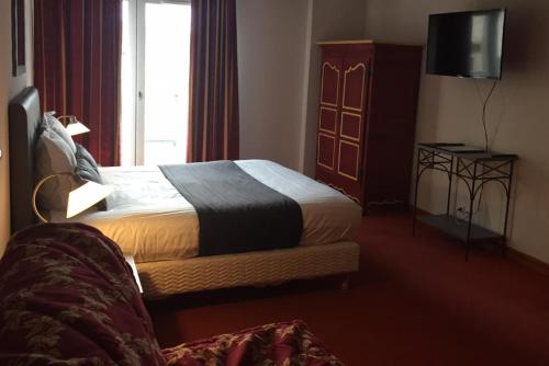 a hotel room with a bed and a window at City Loft Apparthotel in Dijon