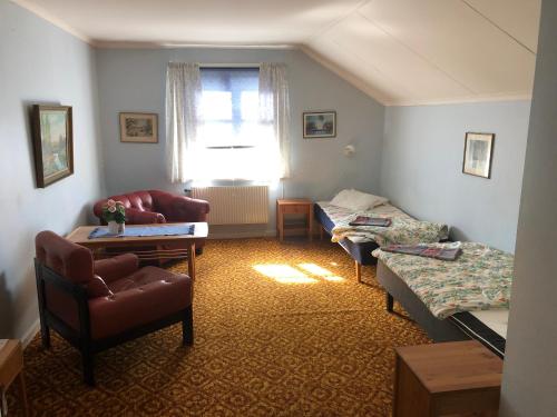 ein Wohnzimmer mit einem Sofa und einem Bett in der Unterkunft Älvtomt in Krylbo