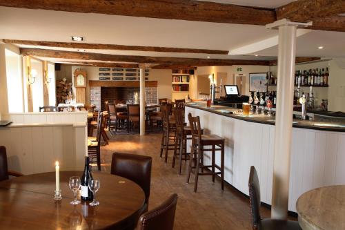 a restaurant with tables and chairs and a bar at The Crown Inn in East Rudham