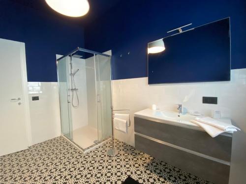 a blue bathroom with a sink and a shower at Appartamento Renzo, Dongo, Lago di Como in Dongo
