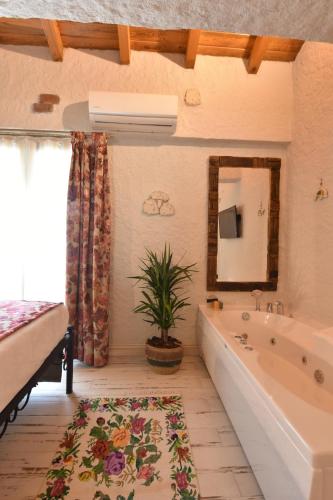uma casa de banho com banheira e uma planta em Alaçatı Aura Plus em Esmirna