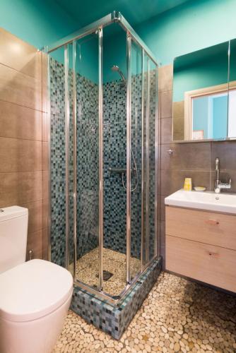 a bathroom with a shower with a toilet and a sink at Dimitra's Garden - Holiday Apartments in Parga