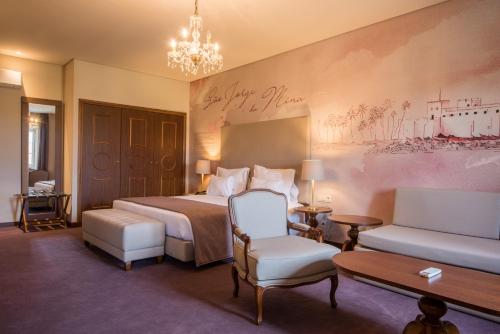 a hotel room with a bed and a chandelier at Vila Gale Collection Elvas in Elvas