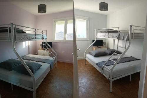 2 stapelbedden in een kamer met een spiegel bij Location Bord de mer, villa de vacances 9 personnes - jardin in Valras-Plage