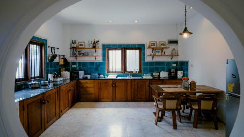 a large kitchen with wooden cabinets and a table at Mammoth Art Studio Pool villa in old city in Chiang Mai