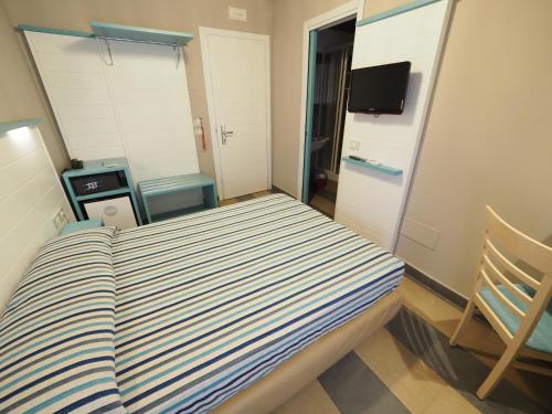 a small bedroom with a bed and a television at Hotel La Spiaggia in Monterosso al Mare