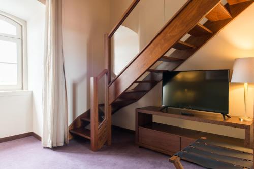 a living room with a tv and a staircase at Vila Gale Collection Elvas in Elvas