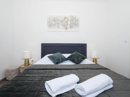een slaapkamer met een groot bed met 2 kussens bij Arena Delight Studio Apartments in Pula
