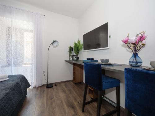 een slaapkamer met een bureau en een vaas met bloemen bij Arena Delight Studio Apartments in Pula