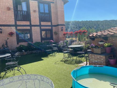a yard with chairs and tables and a building at Posada Real de Carreteros in Casarejos