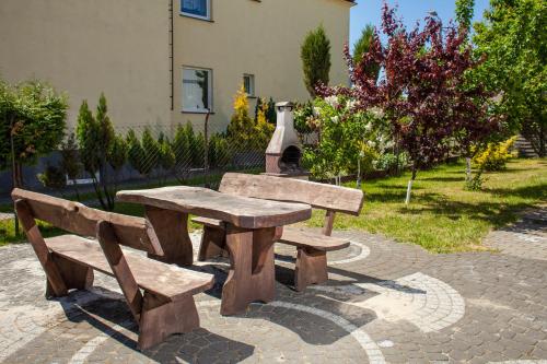 drewniany stół piknikowy i ławka w parku w obiekcie Domek AMPERO 2 we Władysławowie