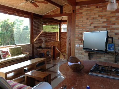 sala de estar con TV de pantalla plana y sofá en Villa La Dolce Vita, en Ilhabela