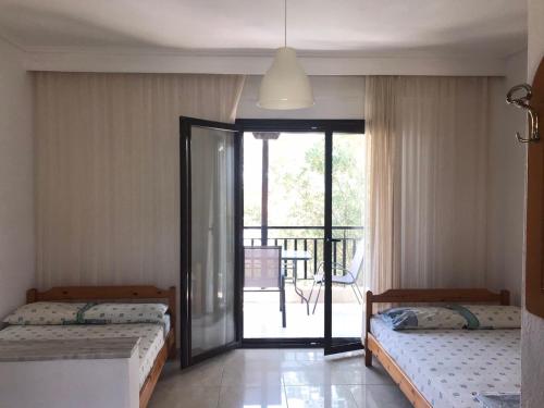 two beds in a room with a balcony at Vila Vergina in Pefkochori