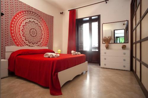 a bedroom with a red bed and a mirror at Appartamenti "Elegante & Romantico" in Trapani