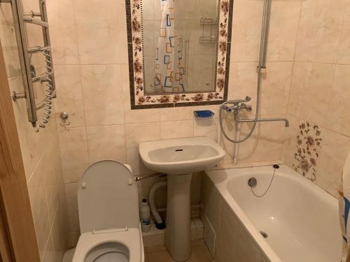 a bathroom with a toilet and a sink and a tub at Квартира Моршин in Morshin