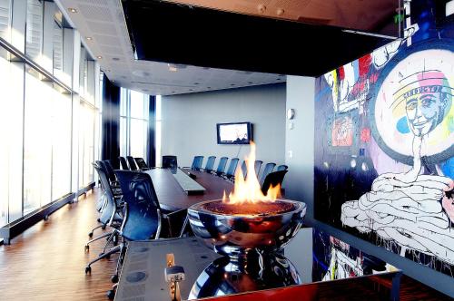 a meeting room with a fireplace in the middle of the room at Clarion Hotel Bergen Airport in Bergen