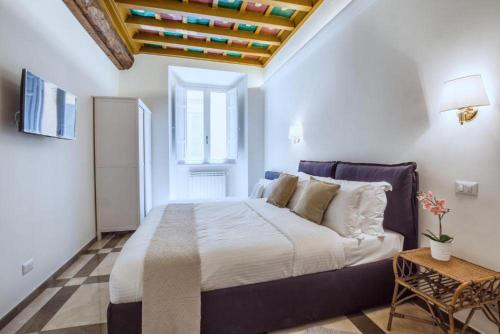 a bedroom with a large bed with a wooden ceiling at iFlat Trevi's Stylish Paradise in Rome