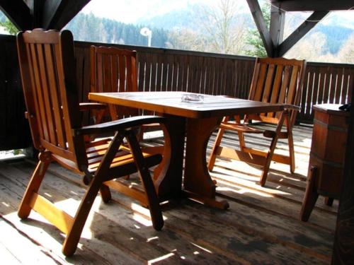 a wooden table and two chairs on a deck at Penzion Muran in Terchová