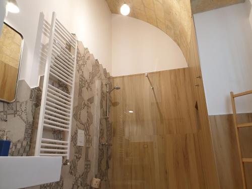 a bathroom with a shower with a wooden door at B&B Novecento Italiano in Altamura