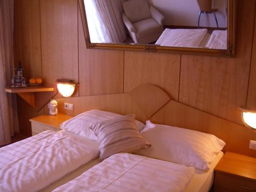 łóżko z 2 poduszkami w pokoju z lustrem w obiekcie LiebesNesterl Bergwirt - Boutique Hotel w mieście Köflach