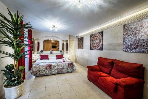 a bedroom with a bed and a couch at Hotel Gines in Gin&eacute;s