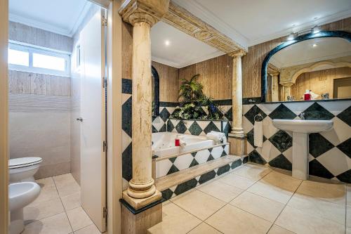 a bathroom with a tub and a toilet and a sink at Hotel Gines in Ginés