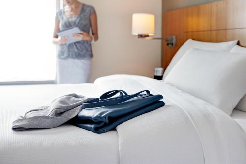 una mujer de pie junto a una cama en una habitación de hotel en Hyatt Place National Harbor, en National Harbor