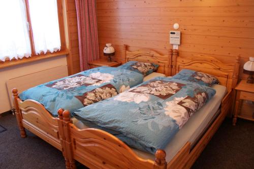 サースフェーにあるAlpenhofの木製の部屋にベッド2台が備わるベッドルーム1室