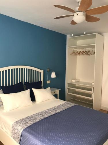 ein blaues Schlafzimmer mit einem Bett und einem Deckenventilator in der Unterkunft Los Caños Home Águilas in Águilas