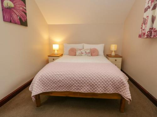 Un dormitorio con una cama grande con dos lámparas. en Woodside Barn, en Ulverston