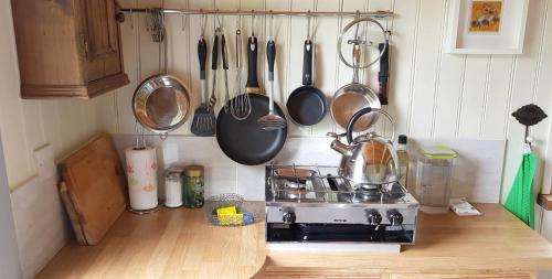 een keuken met een fornuis en potten en pannen aan de muur bij Caban Bryn Arw in Abergavenny