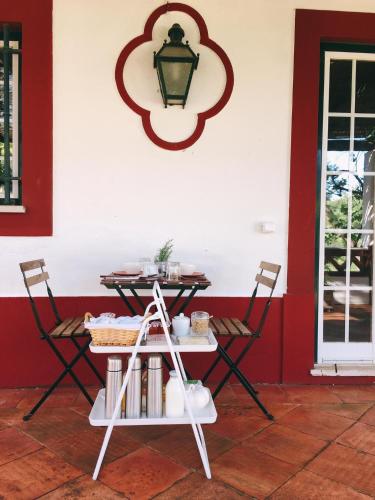a table and chairs in a room with a red wall at Moinho Do Álamo in Montemor-o-Novo