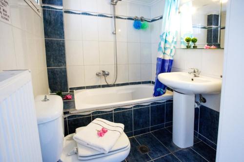 a bathroom with a sink and a toilet and a tub at Ammos Studios & Apartments in Nea Peramos