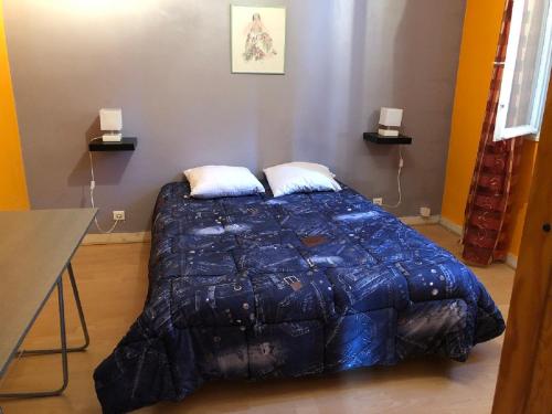 um quarto com uma cama com um edredão azul em Ty Marie - Internet par fibre - Wifi gratuit em Quimper