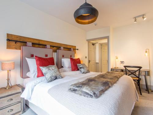 a bedroom with a large white bed with red pillows at The Cornish Arms in Tavistock