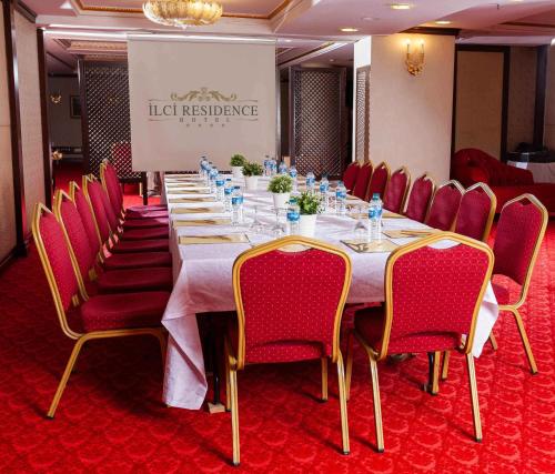 a long table in a room with red chairs at Ilci Residence Hotel in Ankara