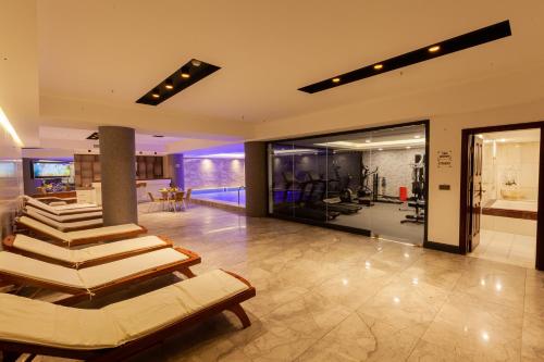 a gym with several lounge chairs and a pool at Ilci Residence Hotel in Ankara