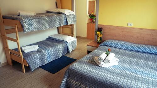 - une chambre avec 2 lits superposés et des serviettes dans l'établissement Hotel Frida, à Rimini