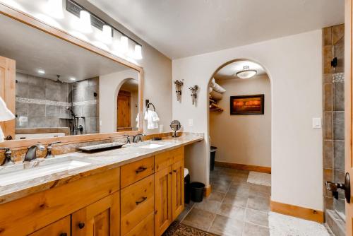 a bathroom with two sinks and a large mirror at Ptarmigan House in Steamboat Springs