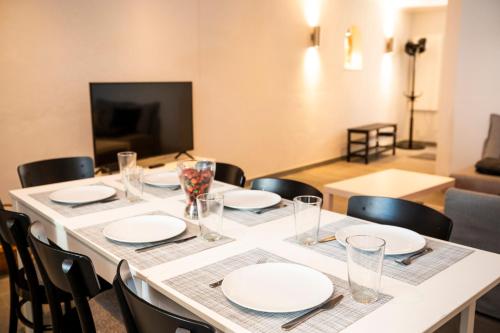 a table with plates and glasses on top of it at Harbour House in Ericeira