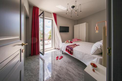 a bedroom with a bed and a large window at Palazzo Novecento in Margherita di Savoia