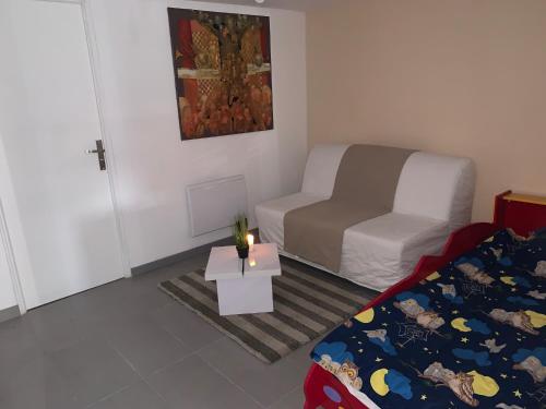 a small room with a bed and a table with a candle at Logement cosy proche Paris et Disneyland in Villiers-sur-Marne