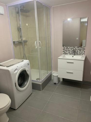 een badkamer met een wasmachine en een douche bij Logement cosy proche Paris et Disneyland in Villiers-sur-Marne