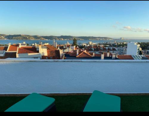 einen Balkon mit Stadtblick und 2 blauen Bänken in der Unterkunft quarto suite em Belém in Lissabon