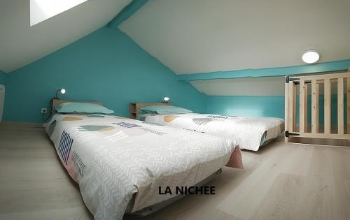 2 letti in una camera con pareti blu di la Nichée a Hauteville-Lompnes